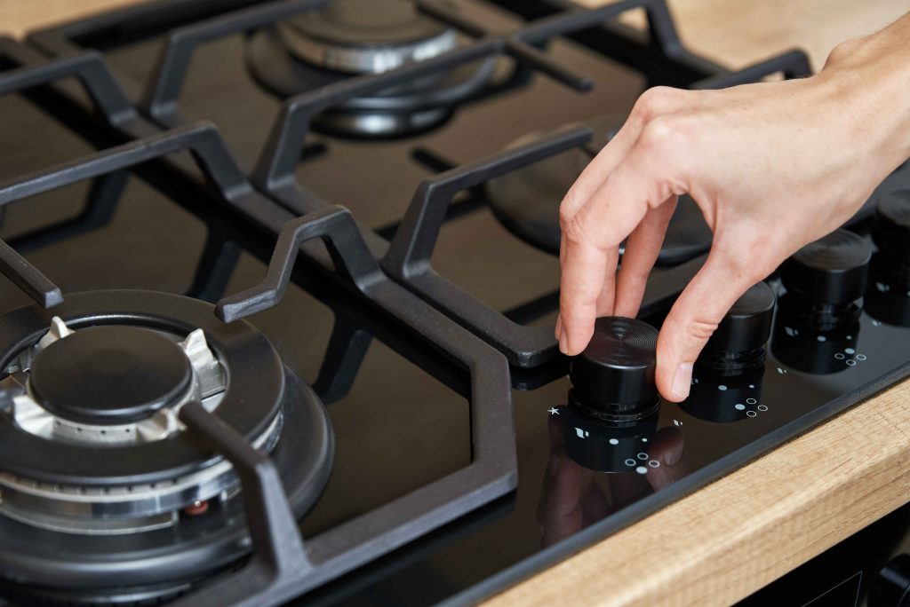 female-hand-use-gas-stove-control-panel-2022-10-27-23-07-00-utc (1)